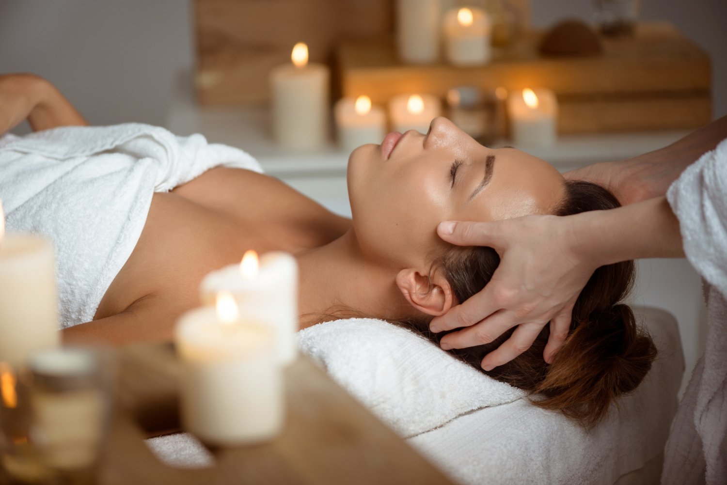 Massage, hammam, soins : quelle expérience choisir dans un spa à Marseille ? 1 Jeune femme ayant le massage du visage relaxant dans le salon spa.